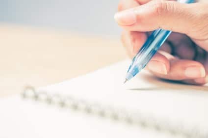 Business women hands working writing notebook on wooden desk, lighing effect